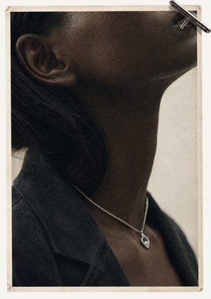 A fine chain necklace worn at the collarbone