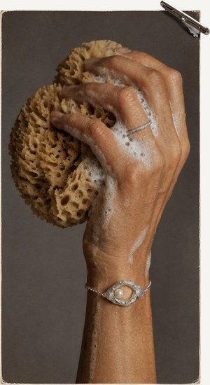 Hand with a gold ring, soaped for polishing