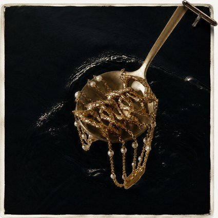 Molten gold form lifted on a spoon